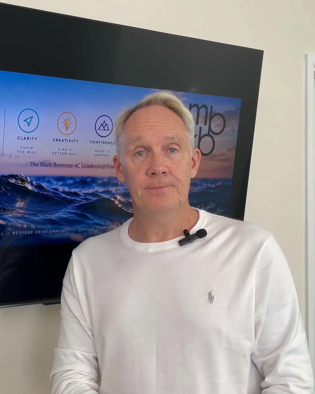 Mark Bremner, CEO of MBKB, standing in front of the 4C Leadership Framework graphic
